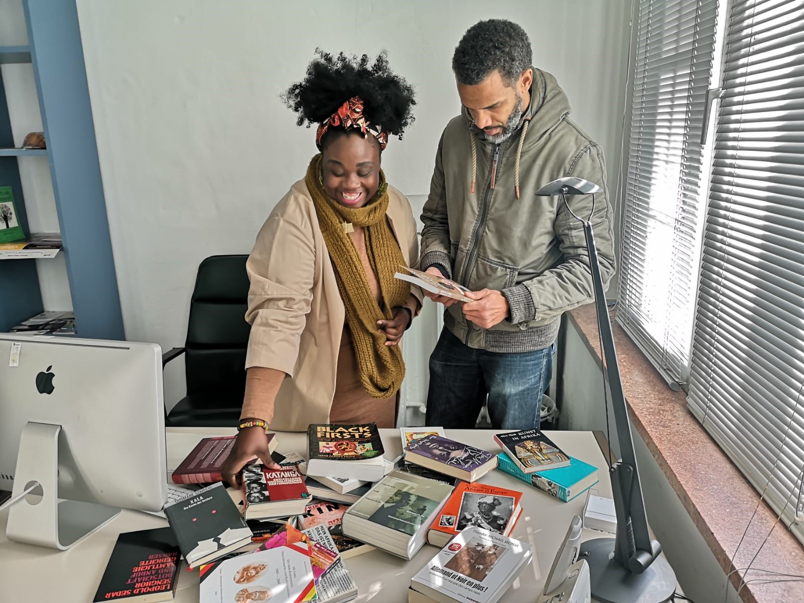 The co-founders of the Theodor Wonja Michael Library, Dr. Njoula Baryoh and Lamin Kargbo, looking through books from Michael's estate. Photo: Sunflower Community Development Group