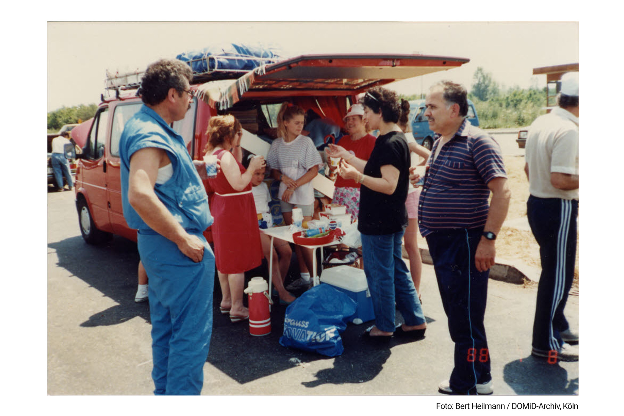 The German family H. and the Turkish family G. knew each other from their common workplace, the car manufacturer Ford. This photo shows them on vacation together in Turkey in 1988. The picture was possibly taken during a break from the car trips that often lasted for days. Installing roof racks on vehicles offered a practical way to accommodate more luggage for the sometimes week-long vacations in the migrants' home countries.