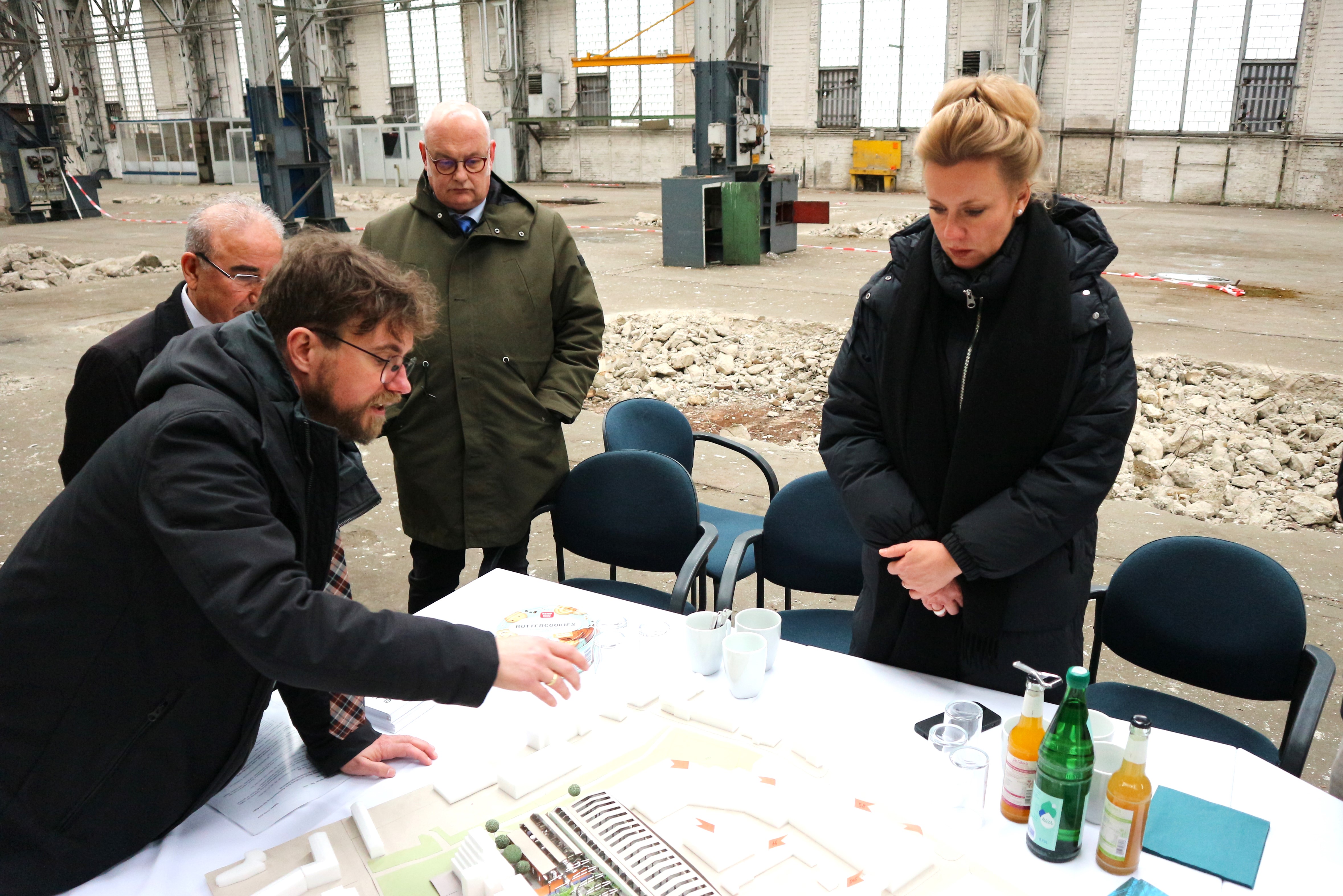 Der Geschäftsführer von DOMiD, Dr. Robert Fuchs, erklärt den Standort anhand eines Architekturmodells der Hallen Kalk (Modell: raumwerk.architekten). Foto: DOMiD-Archiv, Köln