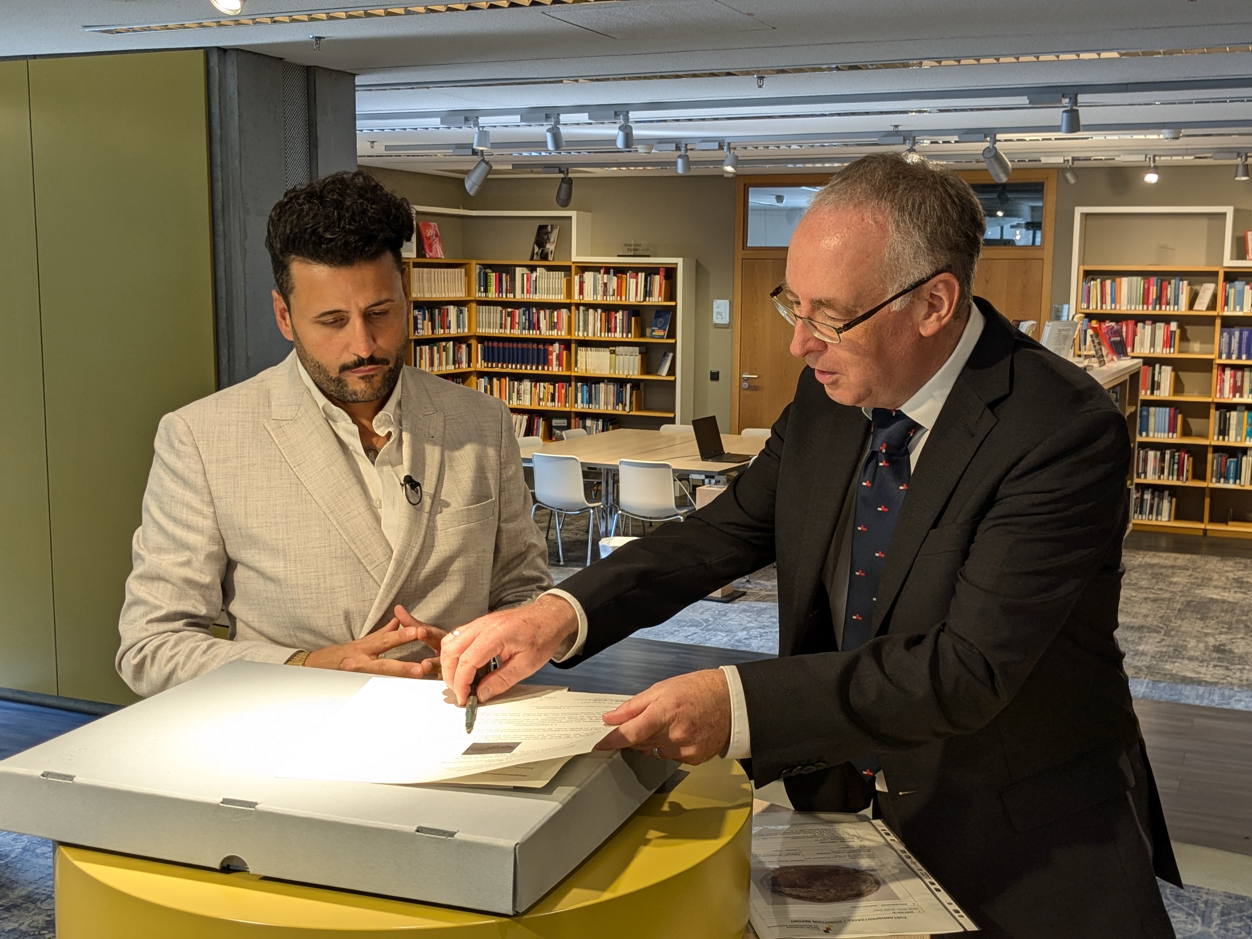 İbrahim Arslan signs the handover protocol for the House of History on behalf of the family. The property is thus transferred back to the family. Arslan then handed over the property to DOMiD. Photo: DOMiD-Archive, Cologne