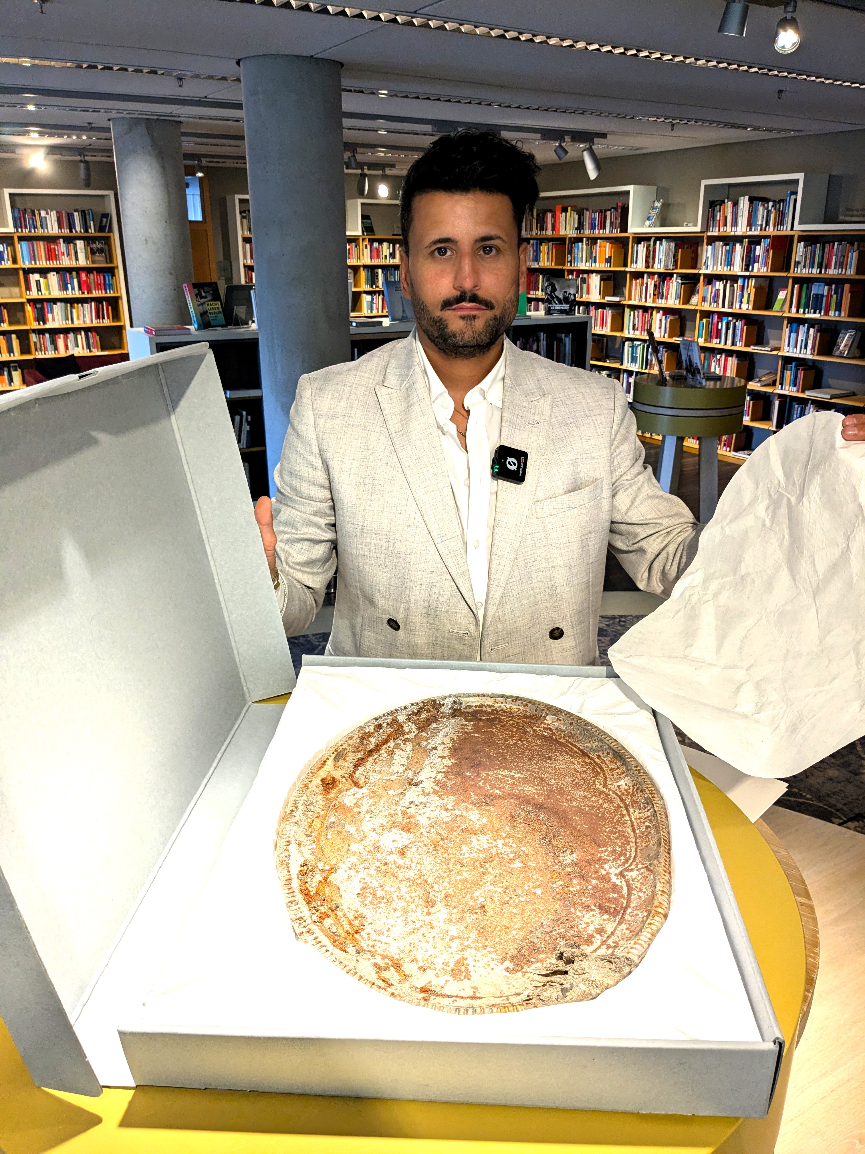 İbrahim Arslan with the family's personal memento, which bears the traces of the night of the fire on November 23, 1992. Photo: DOMiD-Archive, Cologne